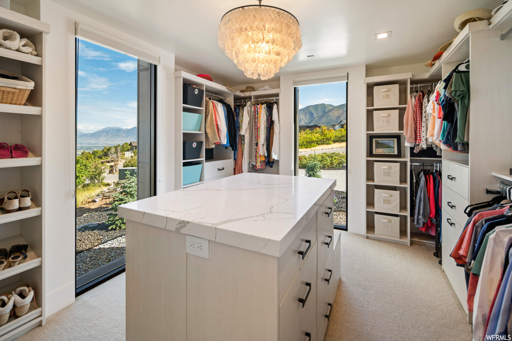 Spacious closet featuring light carpet, an inviting chandelier, and a mountain view