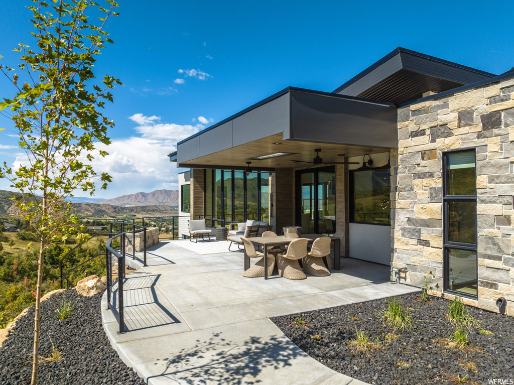 View of patio / terrace featuring ceiling fan, a mountain view, and an outdoor living space