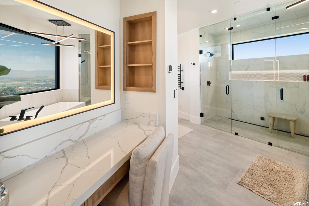 Bathroom featuring shower with separate bathtub, built in shelves, and tile floors