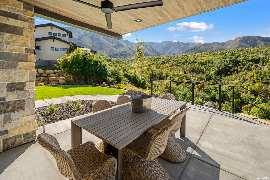 View of patio with a mountain view and ceiling fan