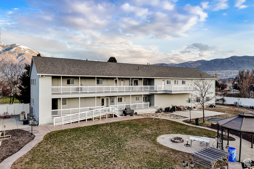 View of front of home featuring a patio, a balcony, and a mountain view