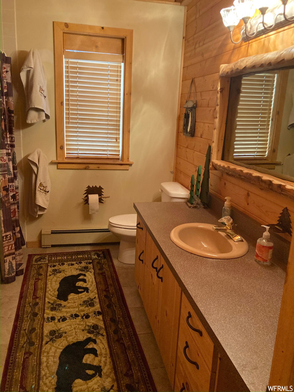 Bathroom featuring toilet, oversized vanity, tile flooring, an inviting chandelier, and a baseboard heating unit