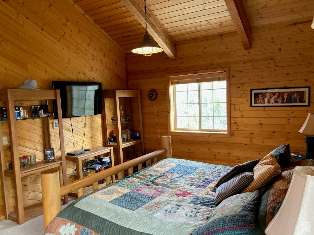 Bedroom featuring beamed ceiling, wooden walls, wood ceiling, and carpet floors