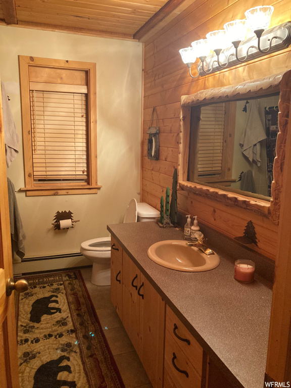 Bathroom featuring toilet, tile floors, wood ceiling, a baseboard heating unit, and oversized vanity