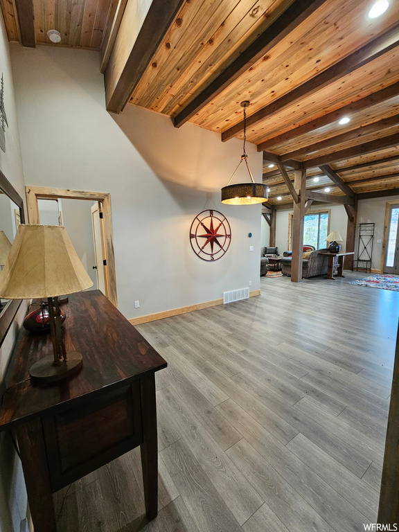 Interior space featuring hardwood / wood-style floors, decorative light fixtures, wooden ceiling, and beam ceiling