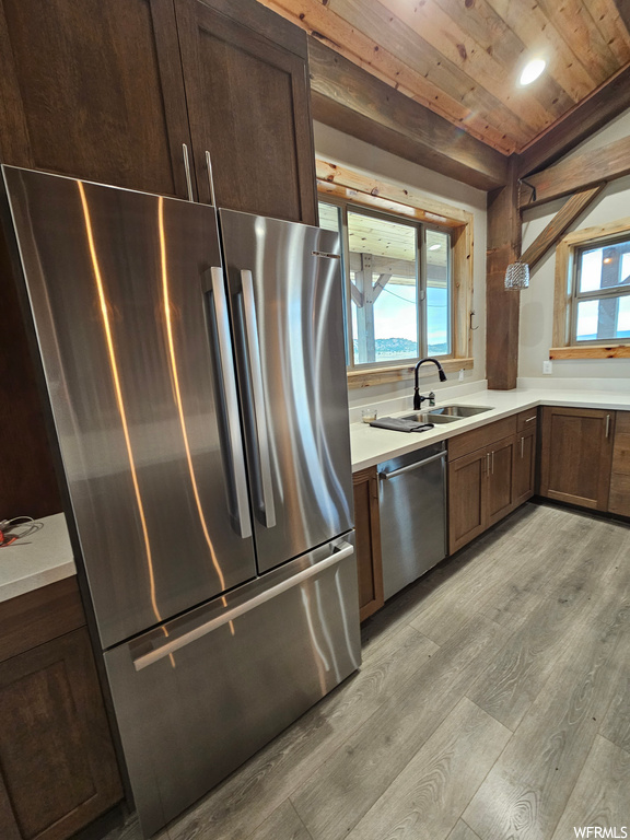 Kitchen with a wealth of natural light, light hardwood / wood-style floors, and appliances with stainless steel finishes