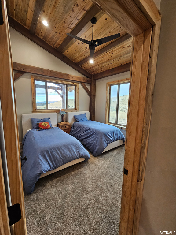 Carpeted bedroom with lofted ceiling with beams, ceiling fan, and wooden ceiling