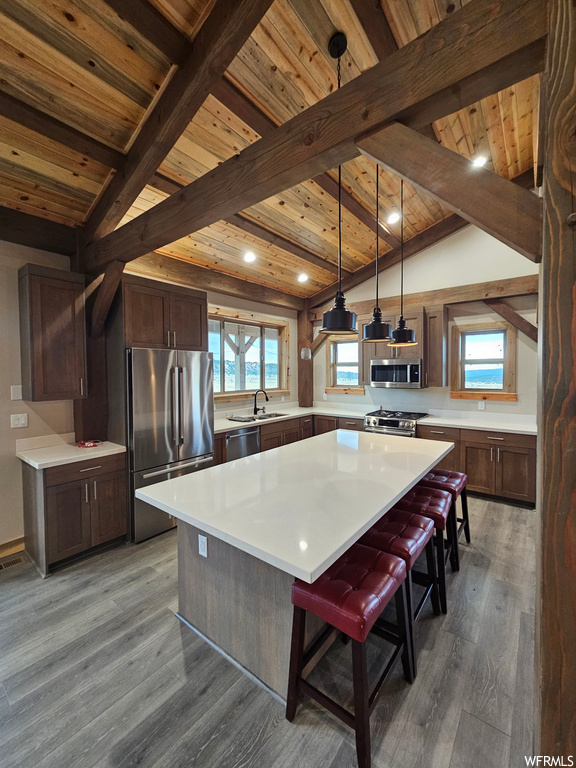 Kitchen featuring hanging light fixtures, a center island, and dark wood-type flooring