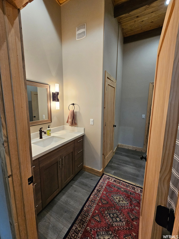 Bathroom with hardwood / wood-style floors, vanity, and wooden ceiling