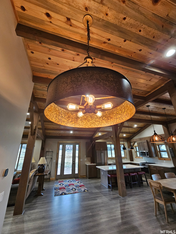 Foyer entrance with dark hardwood / wood-style flooring, lofted ceiling, a notable chandelier, and wood ceiling