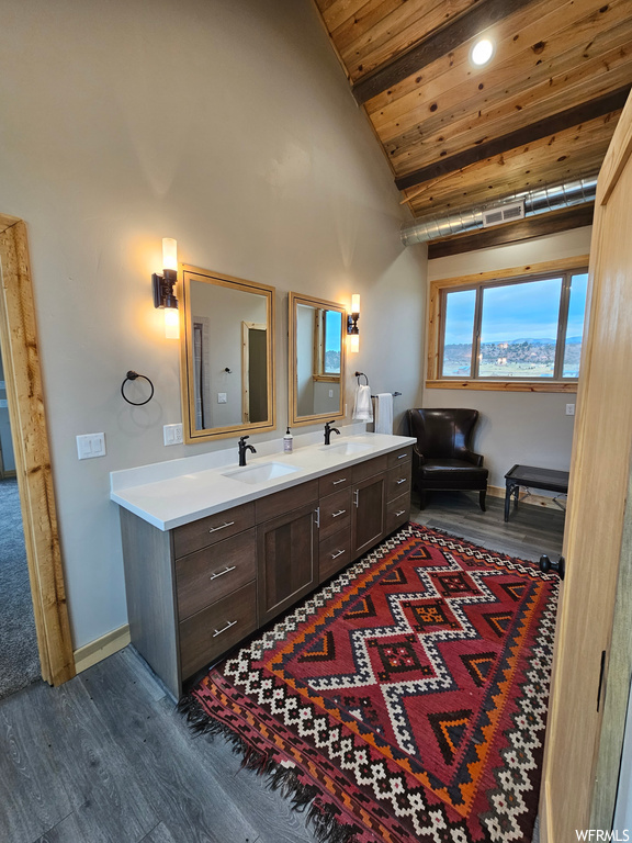 Bathroom with high vaulted ceiling, wood-type flooring, wood ceiling, and dual vanity