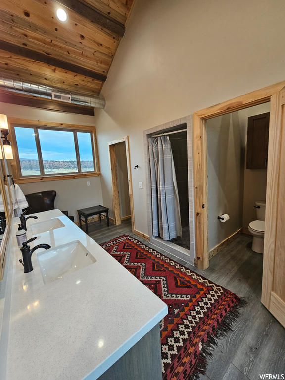 Bathroom featuring toilet, high vaulted ceiling, double sink vanity, wood ceiling, and wood-type flooring