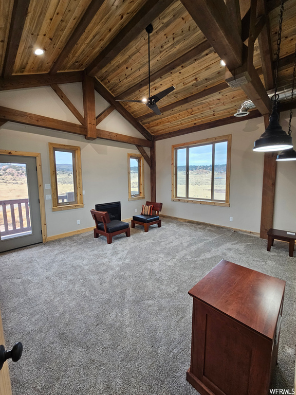 Living area with vaulted ceiling with beams, ceiling fan, light carpet, and wood ceiling