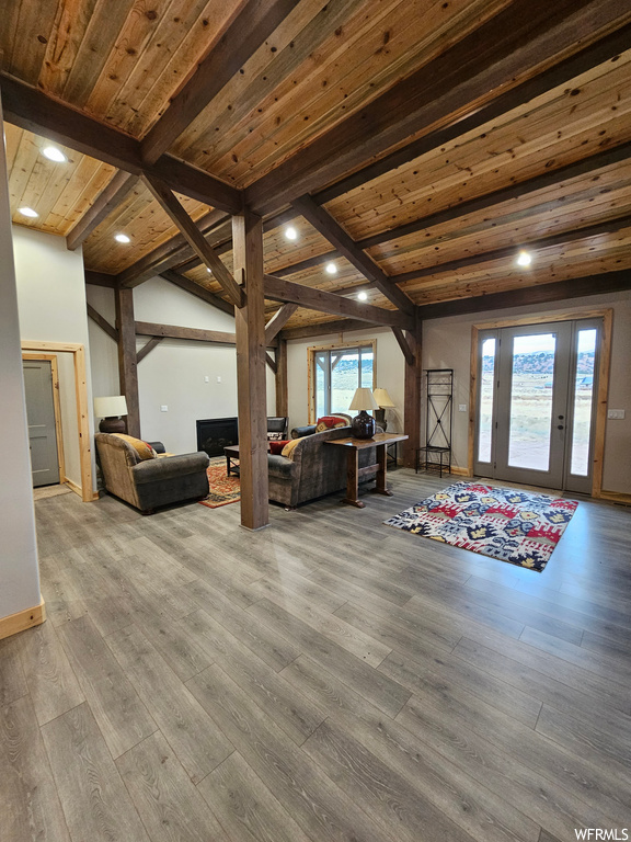 Living room with light wood-type flooring, vaulted ceiling with beams, and wooden ceiling