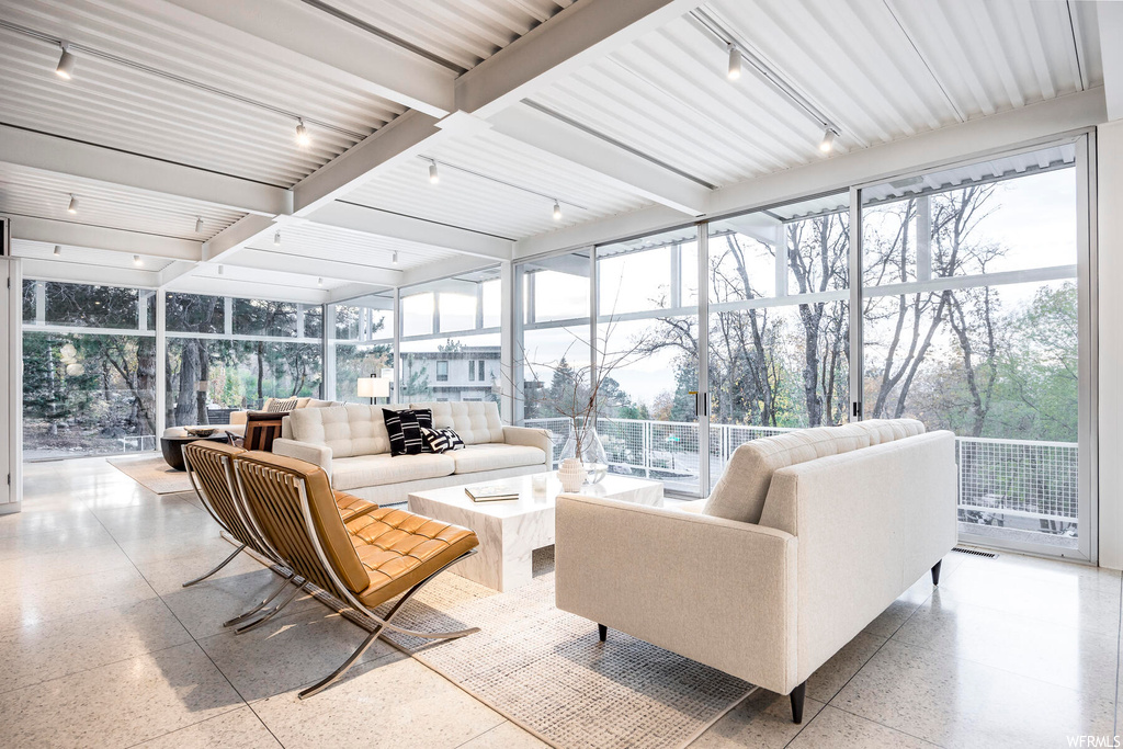 Sunroom featuring track lighting and beamed ceiling