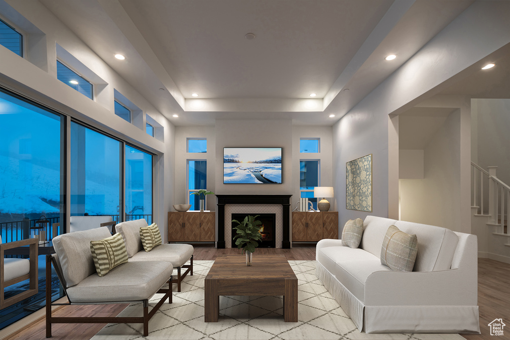 Living room with a tray ceiling and light hardwood / wood-style floors