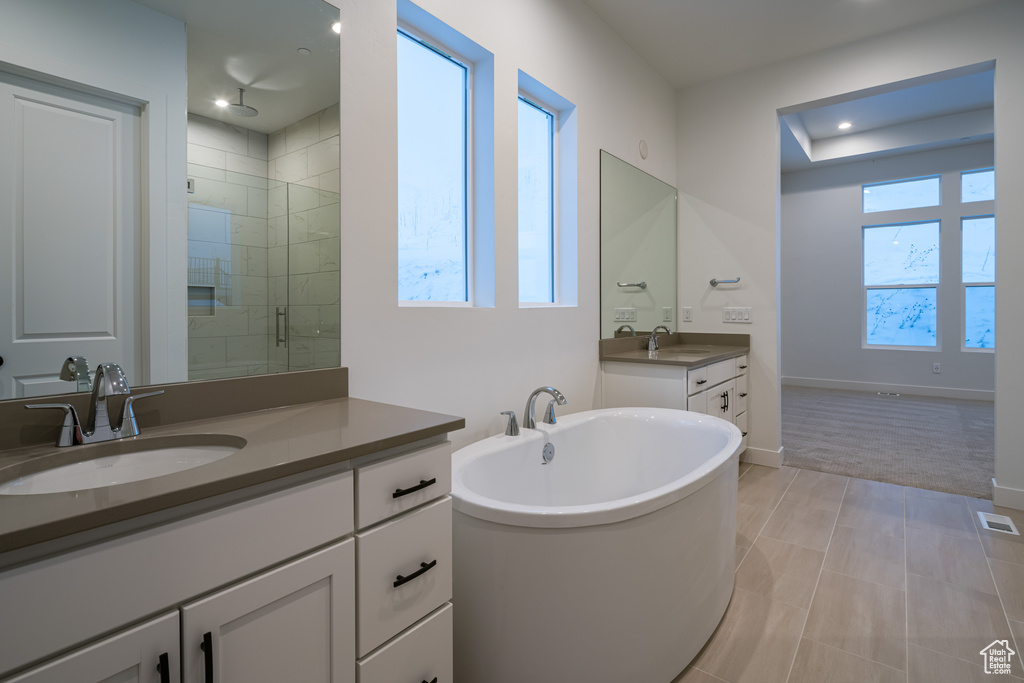 Bathroom with plenty of natural light, dual vanity, separate shower and tub, and tile flooring