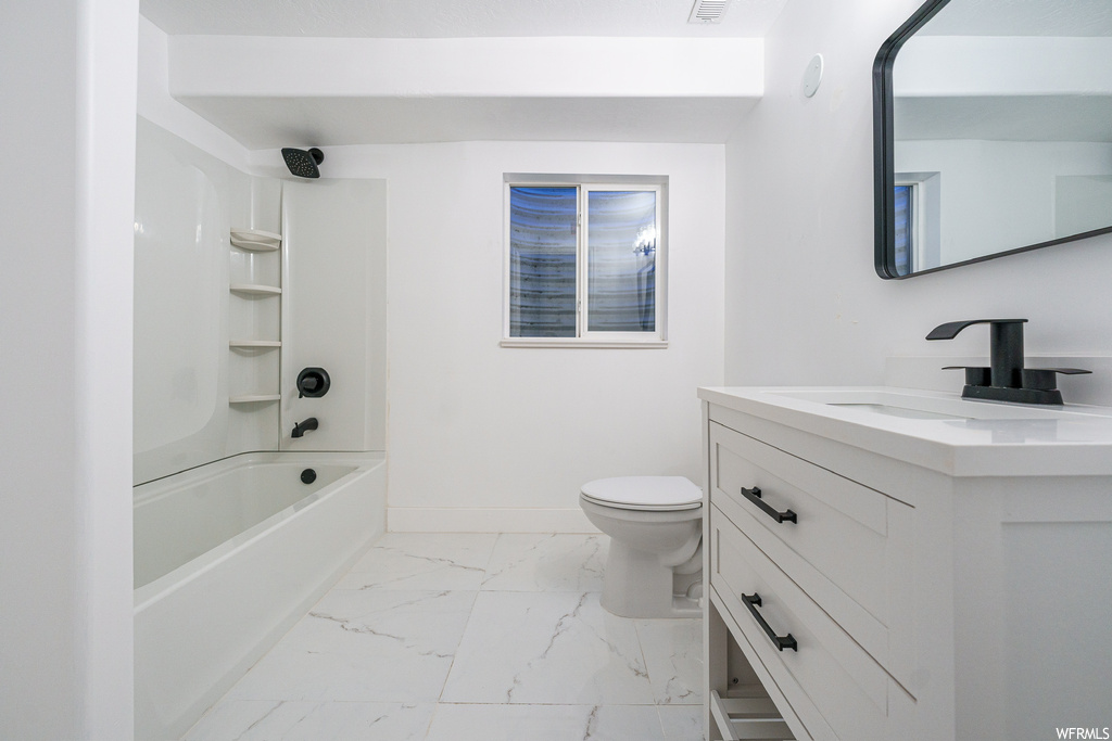 Full bathroom featuring tile flooring, washtub / shower combination, vanity with extensive cabinet space, and toilet