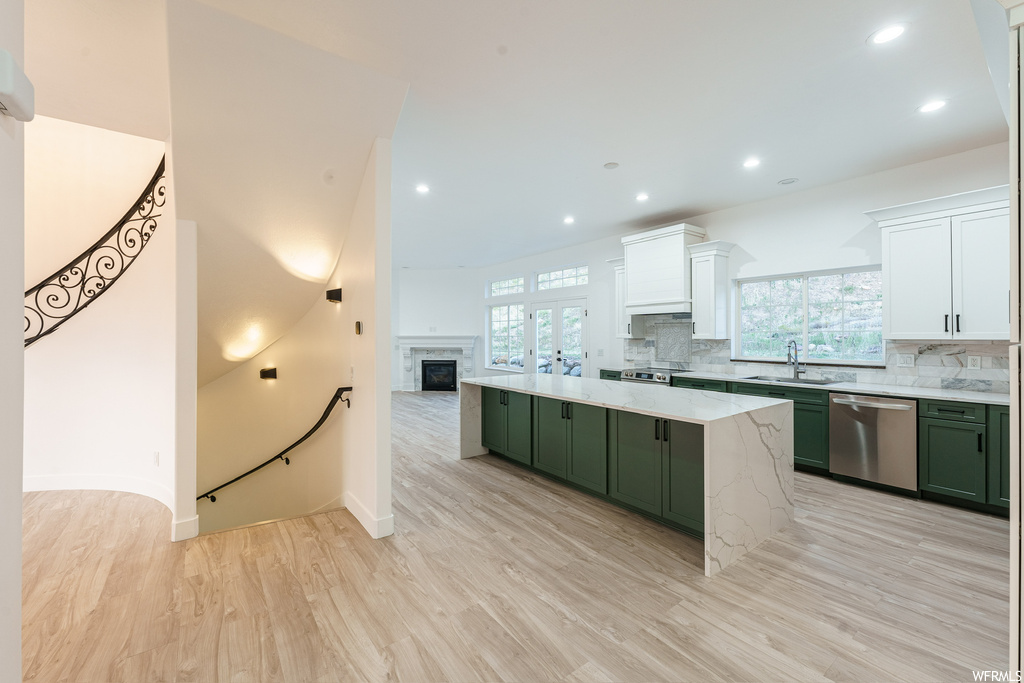 Kitchen featuring stainless steel appliances, a wealth of natural light, white cabinets, and green cabinets