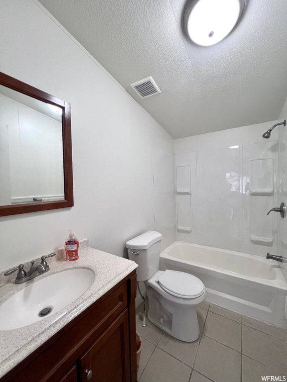 Full bathroom with toilet, a textured ceiling, vanity with extensive cabinet space,  shower combination, and tile flooring