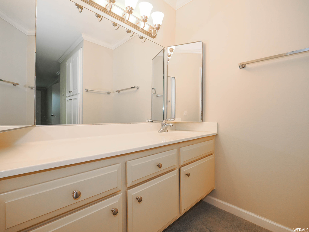 Bathroom featuring ornamental molding and large vanity