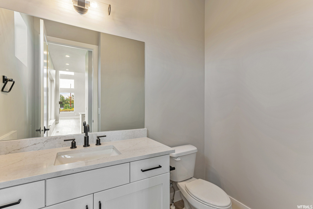 Bathroom featuring toilet and vanity with extensive cabinet space