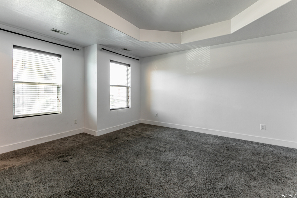 Spare room featuring dark carpet