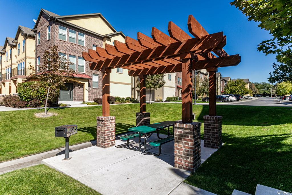 View of property's community with a pergola and a lawn
