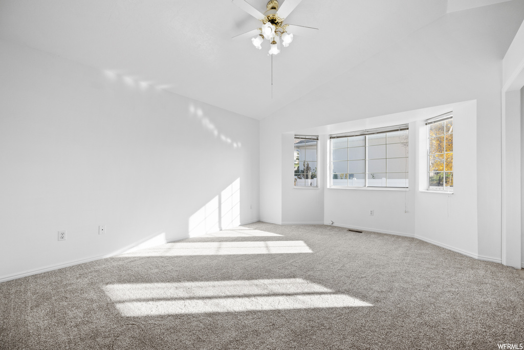 Unfurnished room featuring ceiling fan, light colored carpet, and high vaulted ceiling
