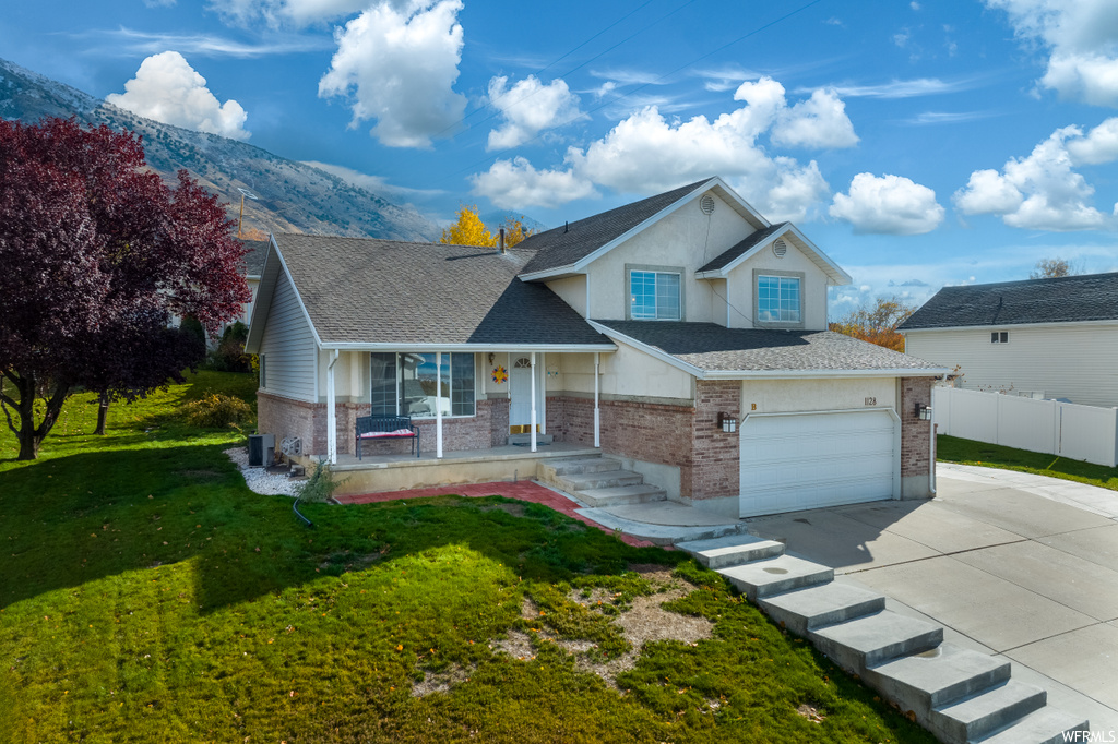 View of front of home featuring a front lawn, a garage, and a mountain view