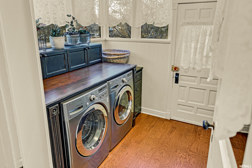 Laundry room featuring light wood-type flooring and washing machine and dryer