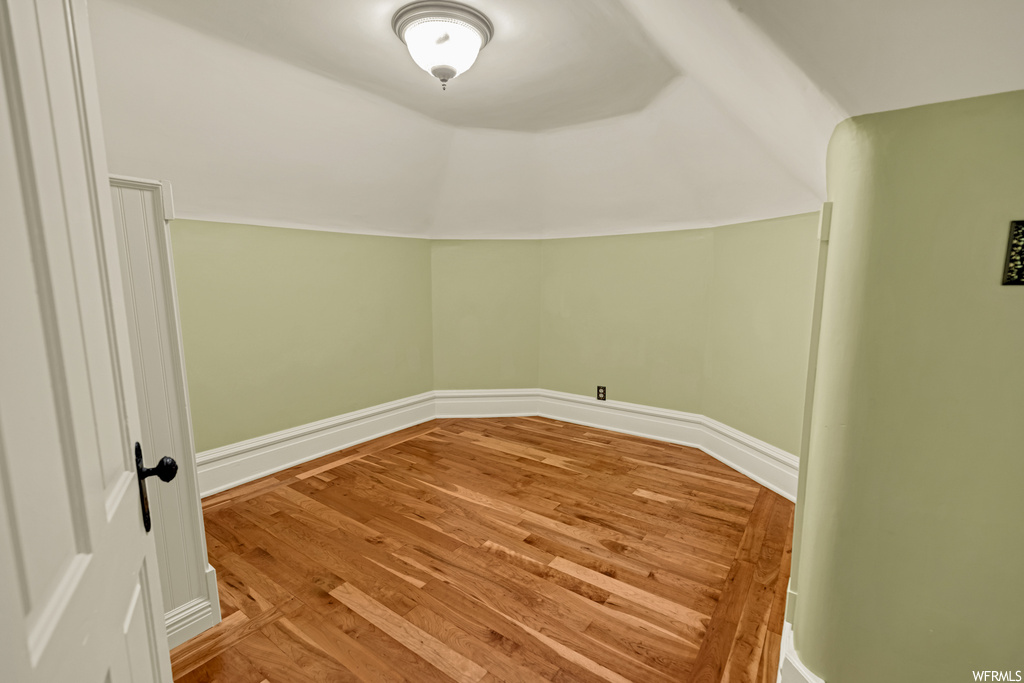 Empty room with lofted ceiling and light hardwood / wood-style floors