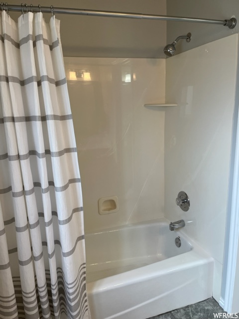 Bathroom with shower / bath combo with shower curtain and tile flooring