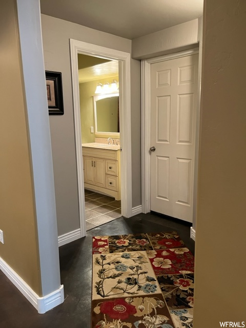 Corridor with dark tile flooring and sink