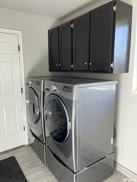 Washroom with cabinets and washer and dryer