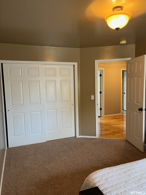 Unfurnished bedroom with wood-type flooring and a closet