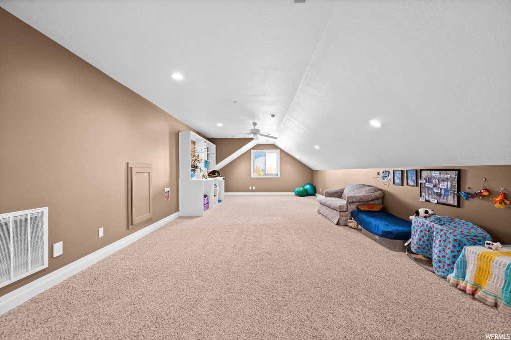 Playroom featuring lofted ceiling, ceiling fan, and light colored carpet