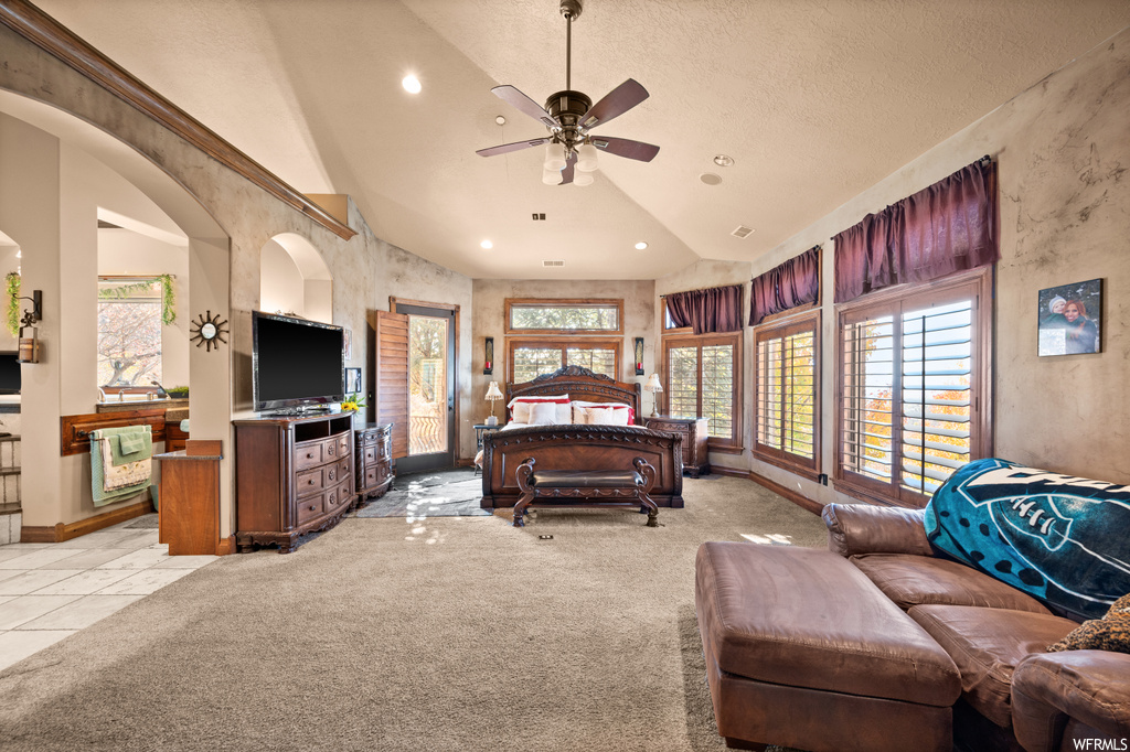 Bedroom featuring ceiling fan, a textured ceiling, light tile floors, and vaulted ceiling