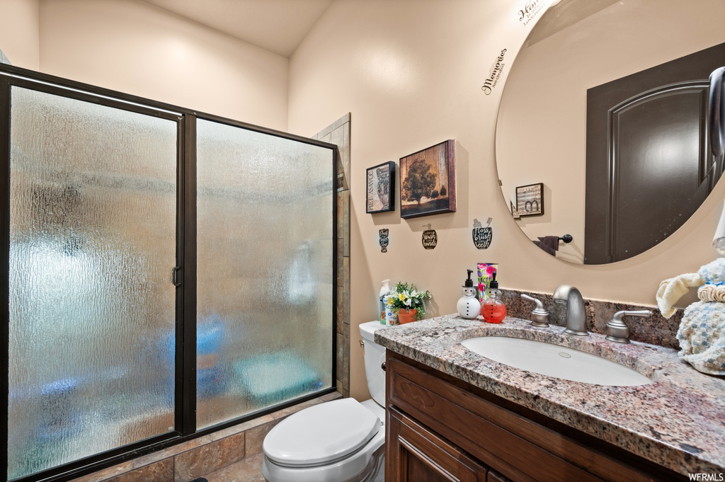 Bathroom with toilet, a shower with shower door, and oversized vanity