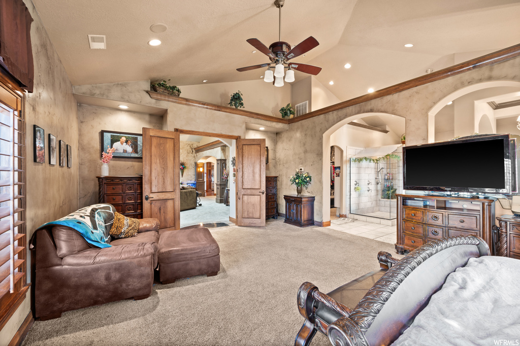 Carpeted living room with ceiling fan and high vaulted ceiling