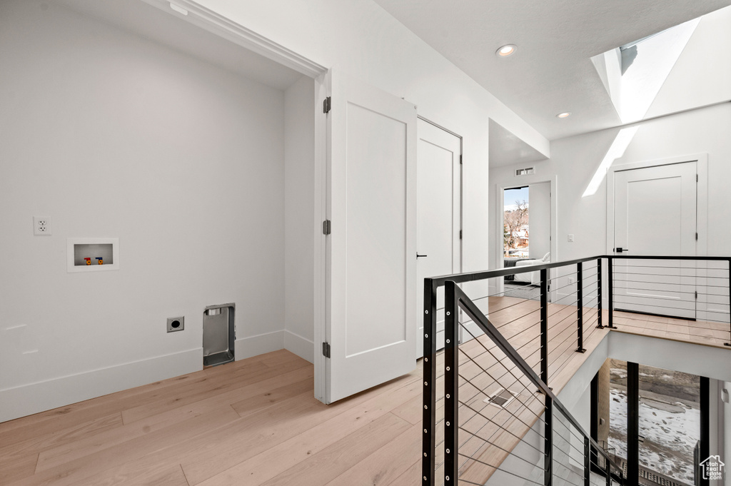 Hallway featuring a skylight and light wood-type flooring