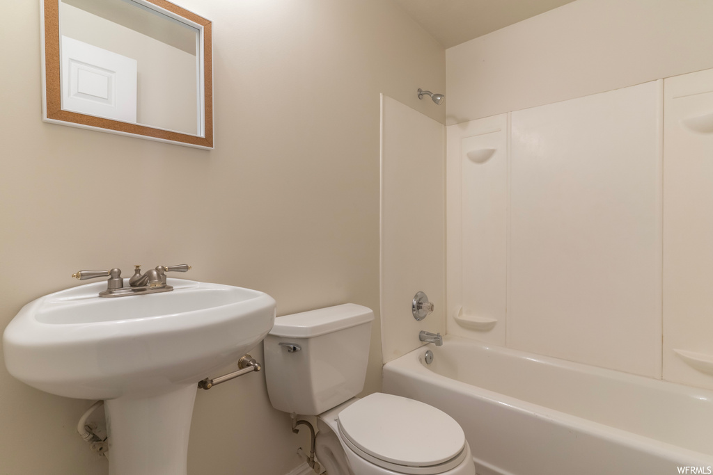 Full bathroom featuring toilet, sink, and washtub / shower combination