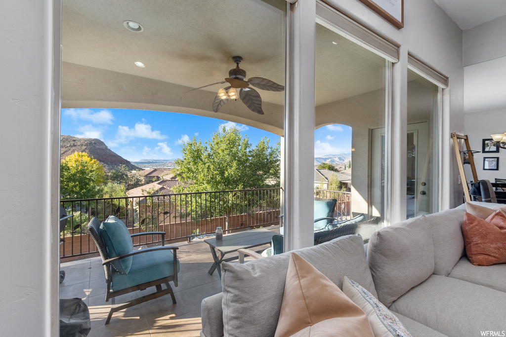 View of patio / terrace with an outdoor living space, ceiling fan, a balcony, and a mountain view