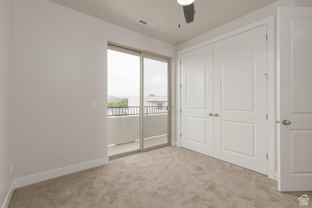 Unfurnished bedroom with ceiling fan and light colored carpet