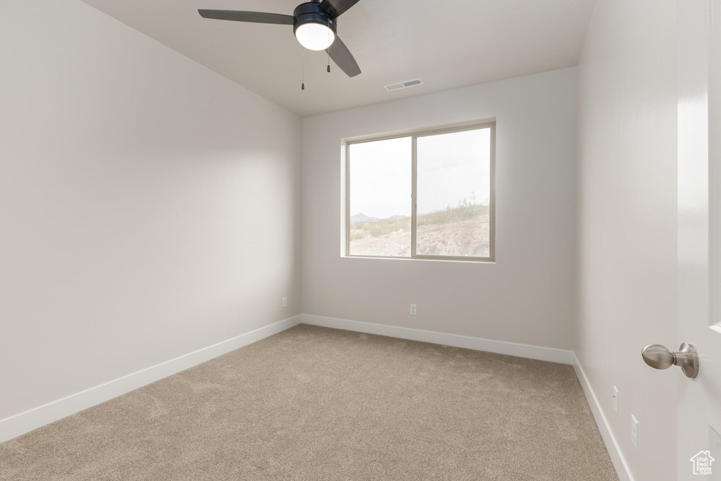 Carpeted spare room with ceiling fan