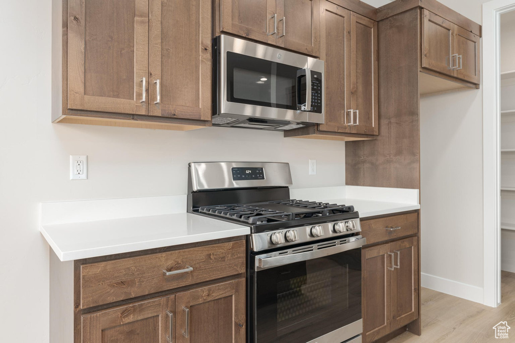 Kitchen featuring stainless steel appliances and light hardwood / wood-style floors