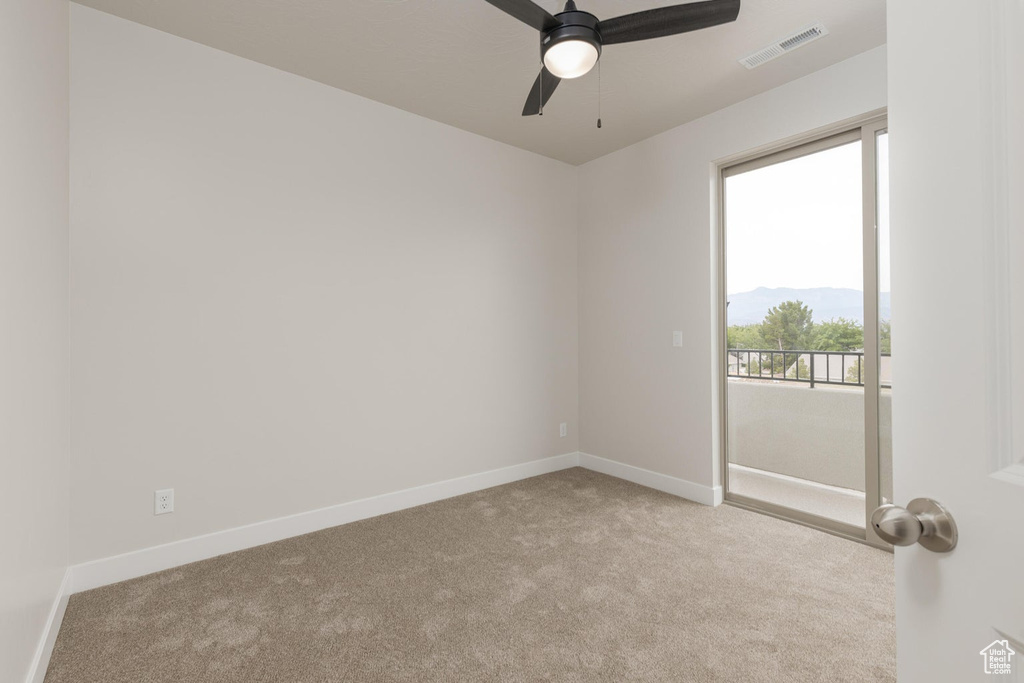 Carpeted empty room with ceiling fan