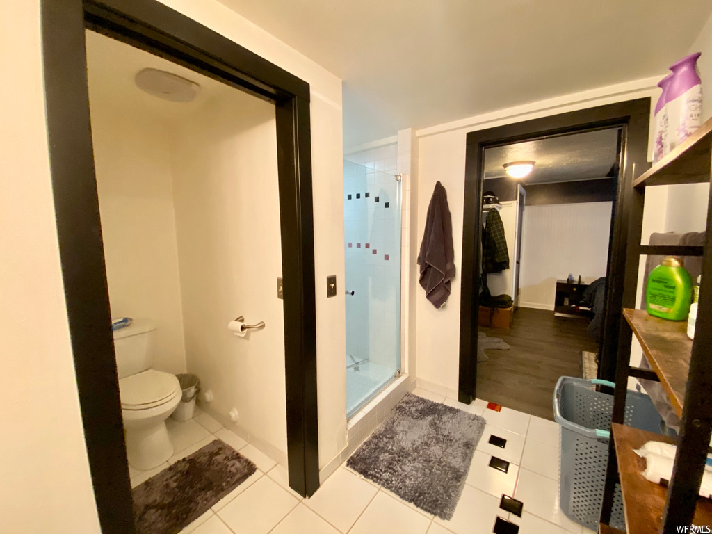 Bathroom featuring toilet, walk in shower, and hardwood / wood-style flooring