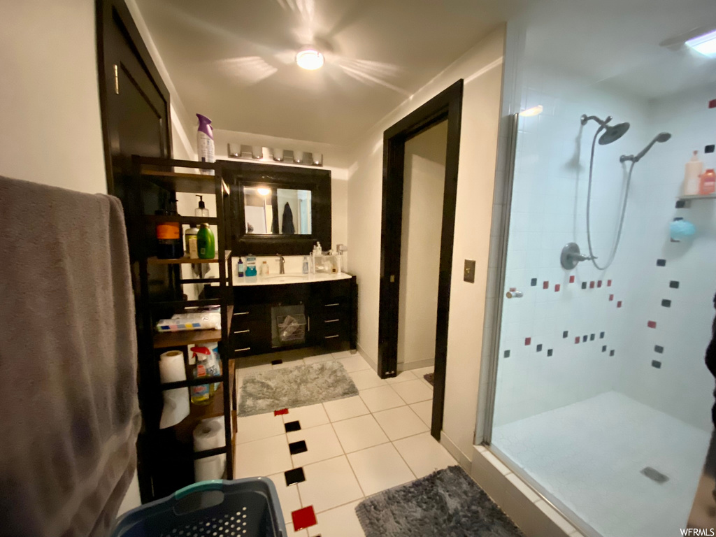 Bathroom featuring vanity, tile flooring, and an enclosed shower