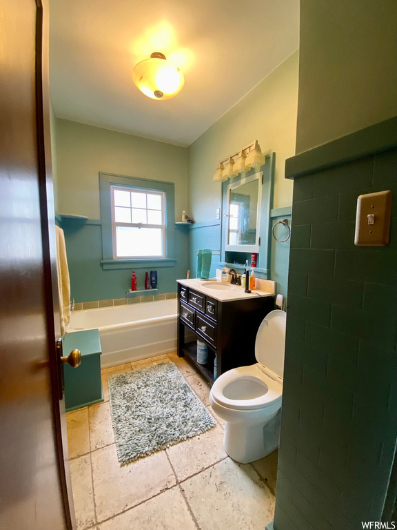 Full bathroom with toilet, tile flooring, shower / tub combination, and vanity with extensive cabinet space